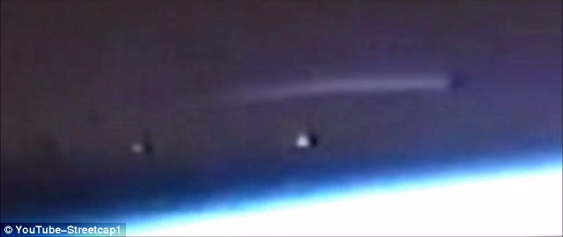 A video uploaded to YouTube by conspiracy theorist Streetcap1 in March shows a long bright light hovering above earth with two mysterious bright objects just below